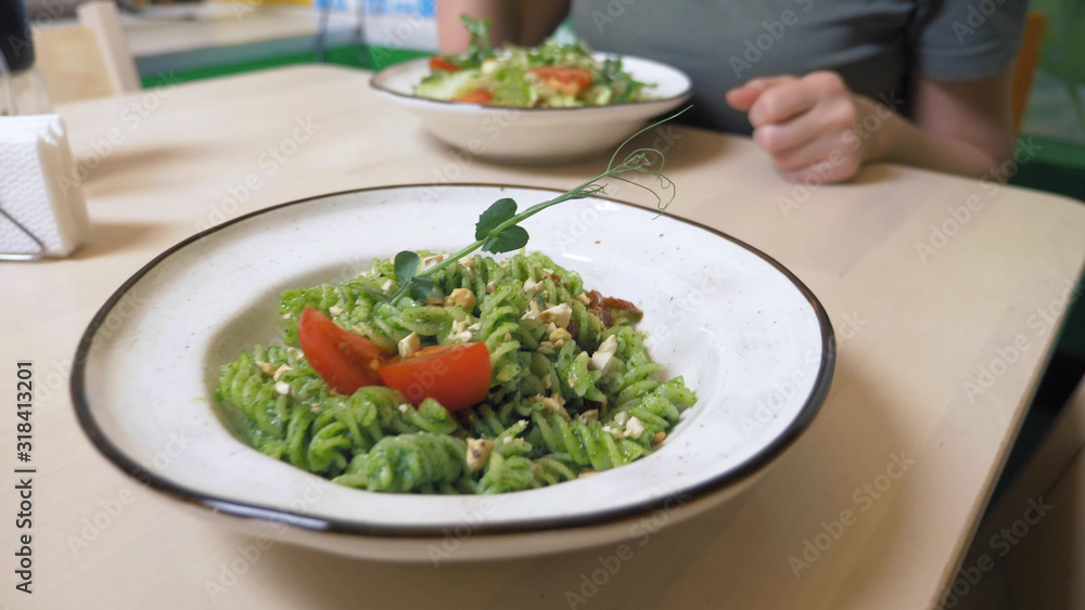 a vegetarian lunch. vegetable salad and pasta with a green sauce. a vegetarian lunch. vegetable salad and pasta with a green sauce.