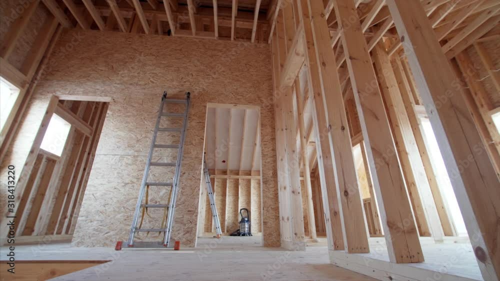 Sliding view from below of Interior of new frame house: spacious room and high steel ladder. No people Sliding view from below of Interior of new frame house: spacious room and high steel ladder. No people