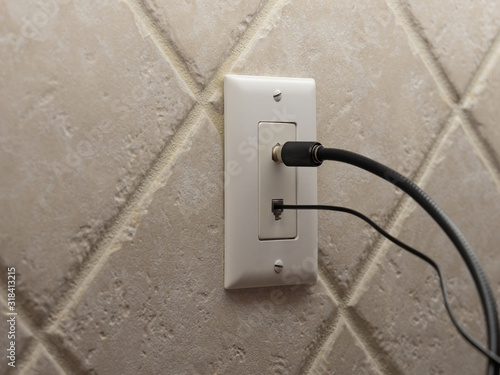 Bild auf Leinwand Coax cable cord and landline phone cord connected to wall outlet