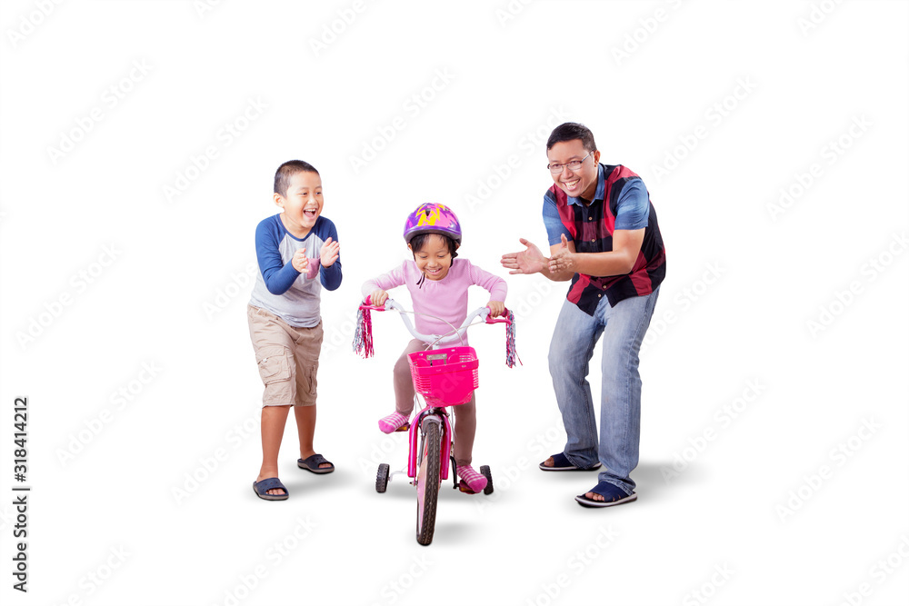 Father and son cheering for the girl riding a bike Father and son cheering for the girl riding a bike