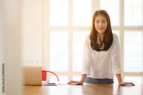 Free Download Head and shoulders portrait of smiling Asian businesswoman, success happy pose. E-commerce, internet technology, or startup small business concept. Modern office or living room with copy space - GFXLoad