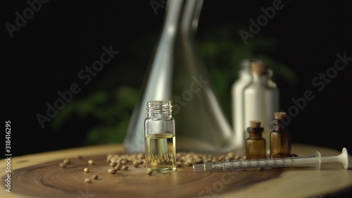 Pharmaceutical medical cbd oils and medications. Various medicine options on the wood table, such as pills and oils in the jars for oral use. Cannabis hemp plant.