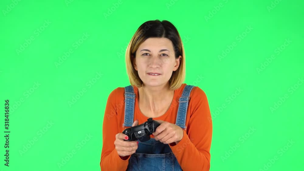 Girl playing a video game using a wireless controller with joy and wow emotions. Green screen Girl playing a video game using a wireless controller with joy and wow emotions. Green screen