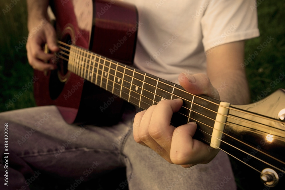 Man playing a red acoustic guitar