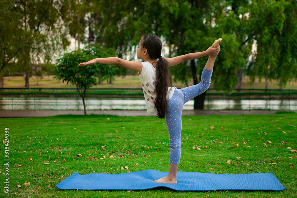 beautiful girl practices yoga at sunrise on the grass in a park beautiful girl practices yoga at sunrise on the grass in a park