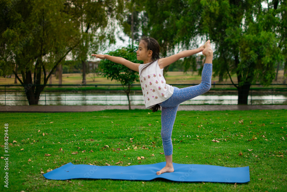 beautiful girl practices yoga at sunrise on the grass in a park beautiful girl practices yoga at sunrise on the grass in a park