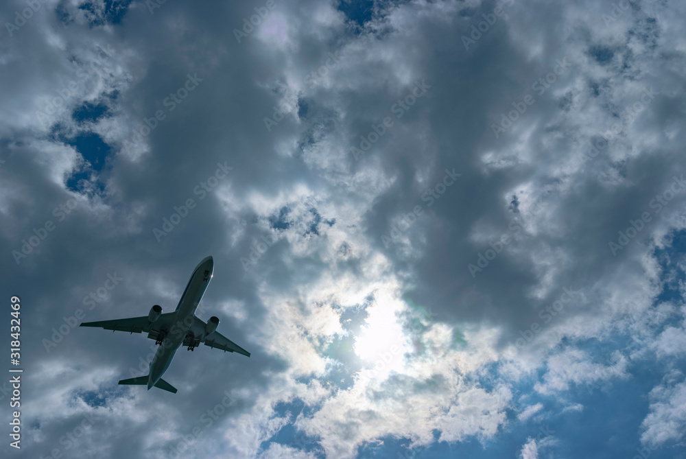 Fototapeta premium 雲の多い空を飛行する一機の旅客機