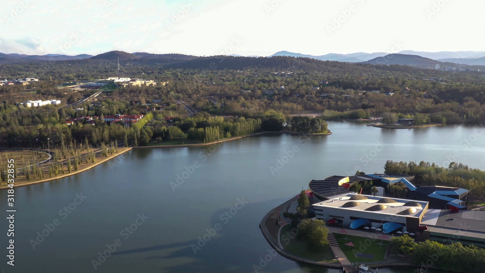 Fototapeta premium Aerial view of Canberra City, Australia, looking over Lake Burley Griffin and Acton Peninsula toward Australian Parliament House on a sunny afternoon 