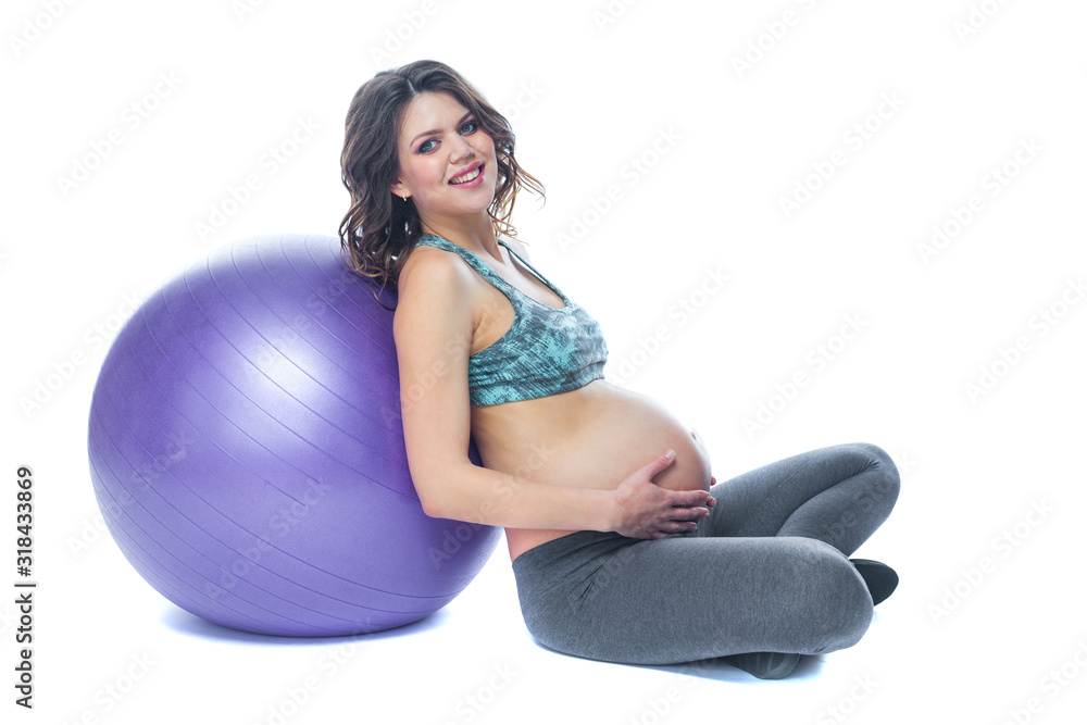 Portrait of a beautiful young pregnant woman exercises with fitball. Working out and fitness, pregnancy concept. Isolated white background. Portrait of a beautiful young pregnant woman exercises with fitball. Working out and fitness, pregnancy concept. Isolated white background.