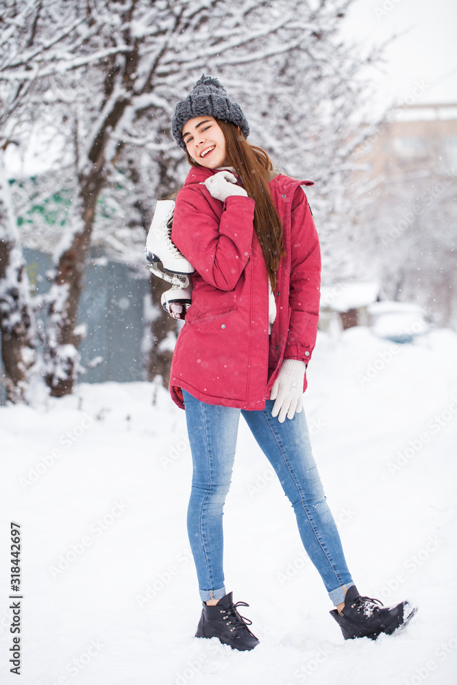 Portrait of a young beautiful woman in a ski suit posing in winter park Portrait of a young beautiful woman in a ski suit posing in winter park