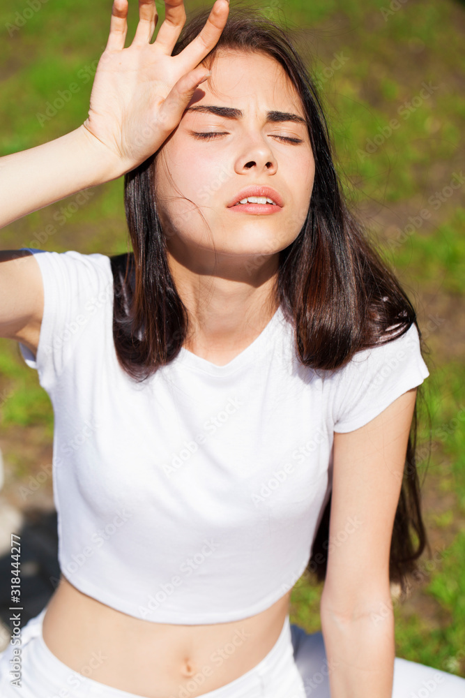 Beautiful brunette woman posing against summer park, bright sunny weather Beautiful brunette woman posing against summer park, bright sunny weather