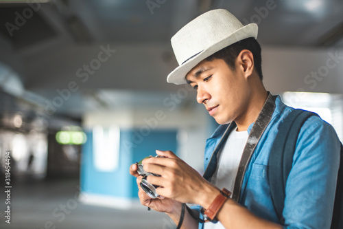 Happy Asian couple traveler holding a mobile phone in station and waiting for train in vacation time. Young Asian Tourists With Backpacks Train travel in Sightseeing City Thailand. © anon