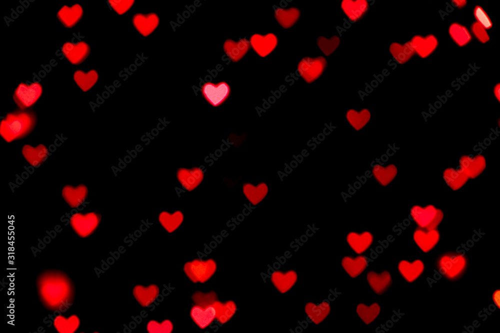 Black background with bright red warm heart shaped bokeh lights. Holiday, Valentines Day background. Ideal to layer with any design. Horizontal
