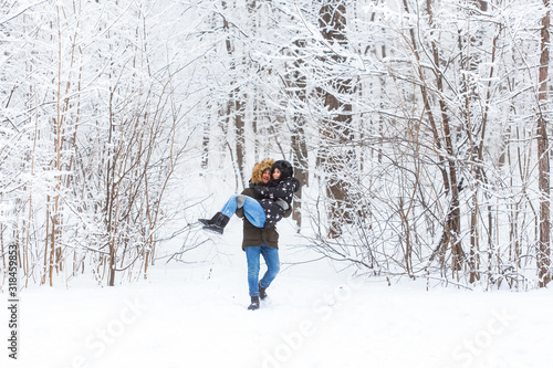 Happy loving couple having fun outdoors in snow park. Winter vacation