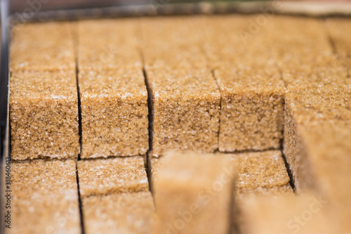 Close-up of granulated brown lump sugar. Brown cane sugar cubes.