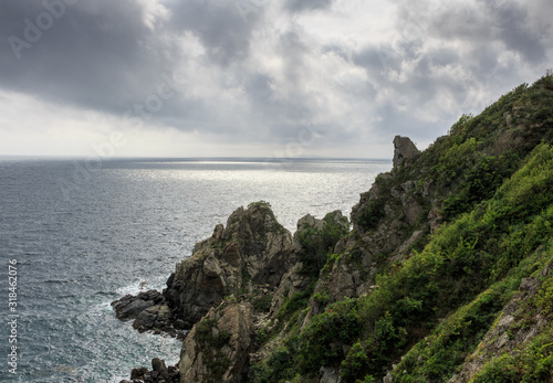 Magnificent seascape overlooking the dark cloudy sky, the steel sea and the high, dangerous rocks.