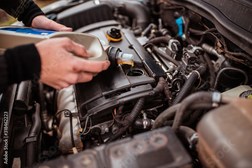 Change the oil, close the selective focus. replacing the fluid in the car. equipment maintenance. Replacing the fluid in the car.  An auto mechanic works and repairs the car. Car service.