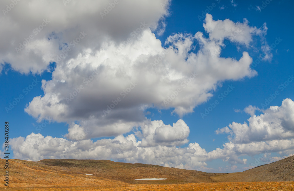 Desert hills and picturesque blue sky with white clouds