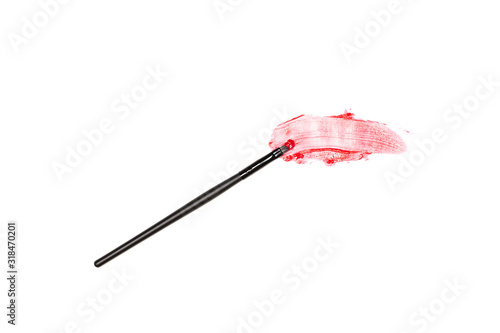 Smeared red lipstick lip makeup brush stroke on white background - top view