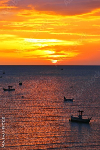 Group of fishing boat in the sea with sunrise in morning, Prajuabkirikhan province, Thailand photo