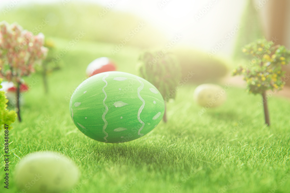 Fototapeta premium Green Easter egg outside in grass with evening sun from behind