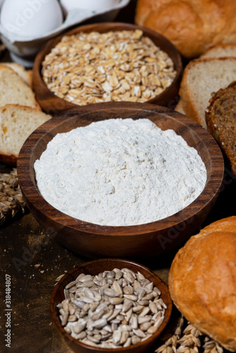 assortment of baked goods and fresh bread on dark background, closeup vertical