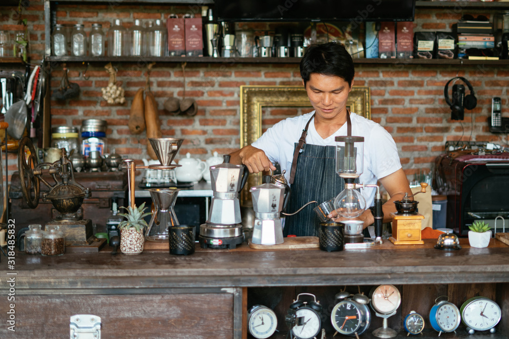 The young man who owns the coffee shop prepares to customers