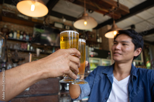 A man wearing a denim shirt and a glass of beer in the bar