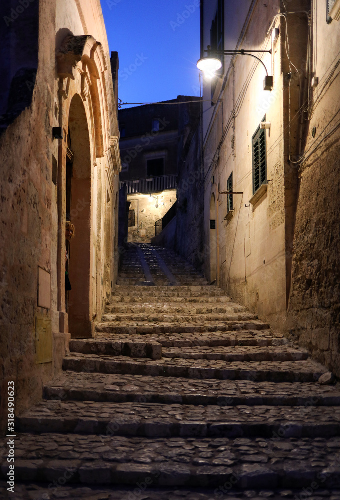Obraz premium Typical cobbled stairs in a side street alleyway iin the Sassi di Matera a historic district in the city of Matera. Basilicata. Italy