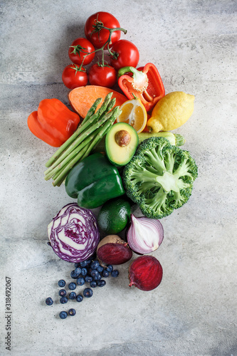 Rainbow colors vegetables and berries background, top view. Detox, vegan food, ingredients for juice and salad.
