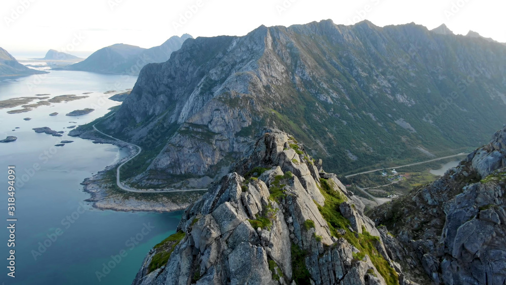 Obraz premium Top view of high stone mountains in Lofoten islands surrounded by the sea