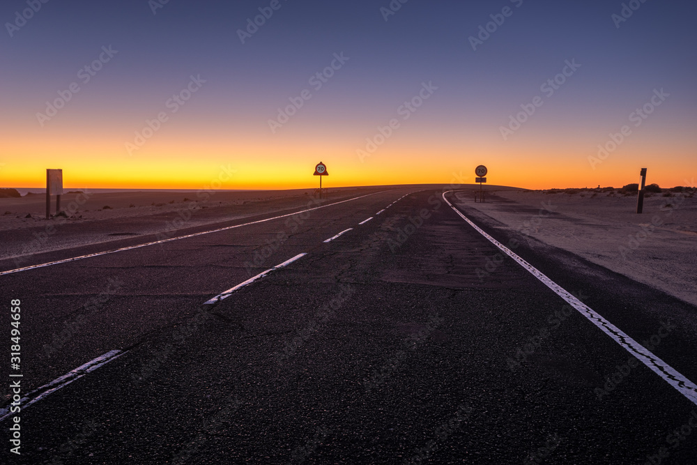 asphalt road running through the sandy desert at night asphalt road running through the sandy desert at night