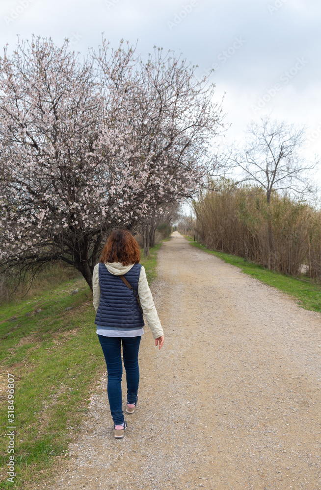 Woman walking on a rural road in autumn winter Woman walking on a rural road in autumn winter