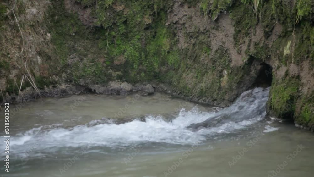 View of a small river waterfall. The river flows through the town View of a small river waterfall. The river flows through the town