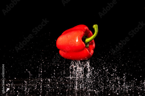 Slices of red peppers falling into the water