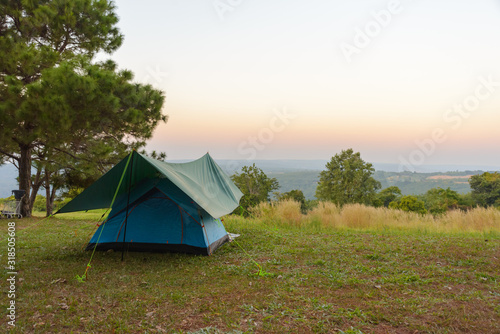 Tourist tent on among meadow in the sunset overlooking mountains. outdoors camping