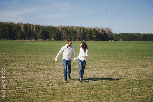 Happy girl and guy running and hugging on the field, love story travel concept, selective focus