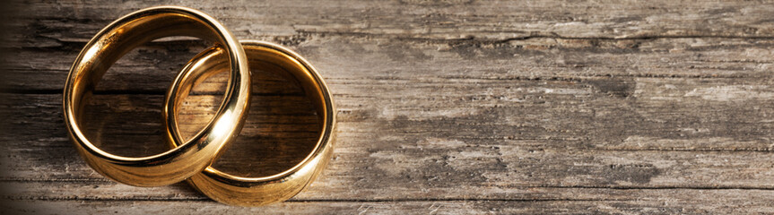 Golden wedding rings on wood