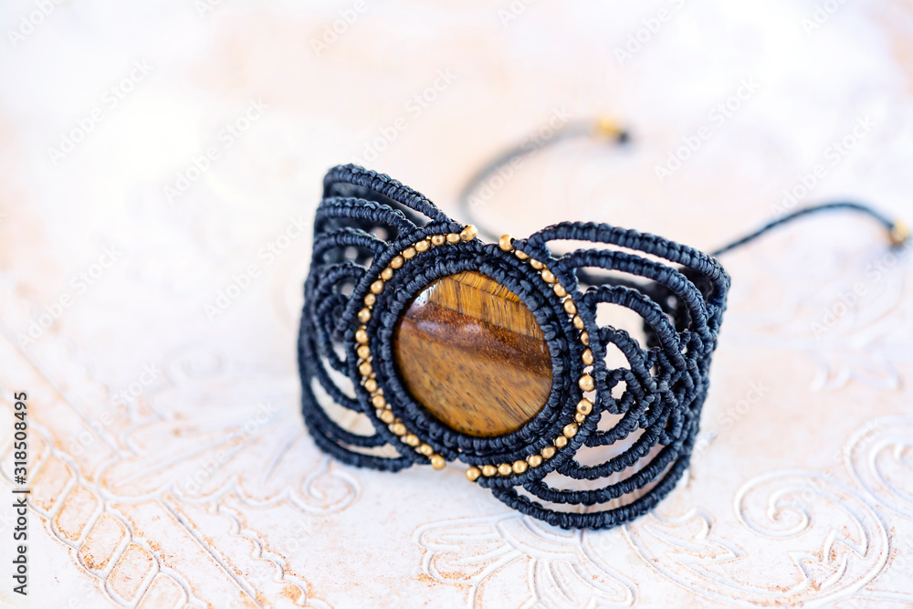 Fototapeta premium Stylish boho macrame string natural mineral stone bracelet on white decorative background
