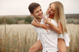 Cute couple in a field. Lady in a white dress. Guy in a white shirt