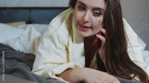 woman plus size in bed talking on a cell phone solves problems. Modern technologies, communication tools, problem solving at a distance. Female professional working online at night