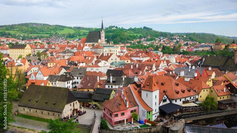 Aerial panoramic view of the typical colorful houses of Cesky Krumlov with St. Vitus Church at the background (Czech Republic)