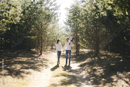 Happy girl and guy with tourist backpack and guitar walking in nature, travel love story concept, selective focus