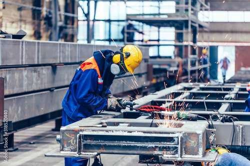 Schilderij op canvas Blue-collar workers at work in a big factory. Labor, industry