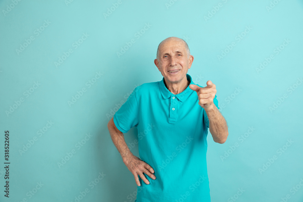 Pointing, choosing you. Caucasian senior man's portrait on blue studio background. Beautiful male emotional model. Concept of human emotions, facial expression, sales, wellbeing, ad. Copyspace. Pointing, choosing you. Caucasian senior man's portrait on blue studio background. Beautiful male emotional model. Concept of human emotions, facial expression, sales, wellbeing, ad. Copyspace.