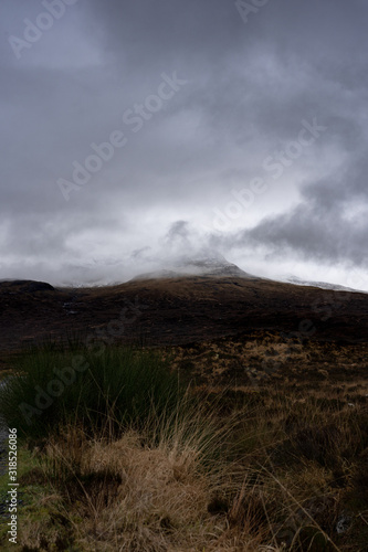 Peak of the mountain hidden in moody clouds