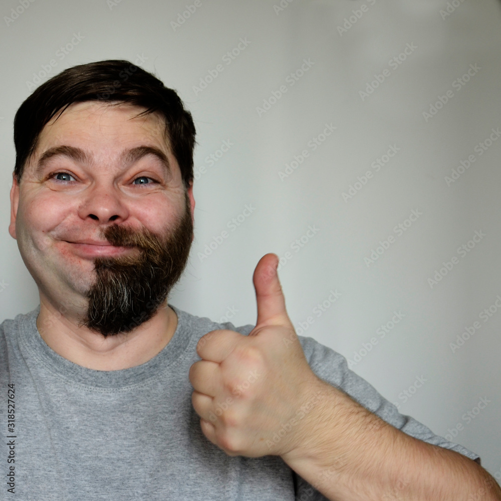 A bearded man with half his face shaved off. Part of the face without a beard. A bearded man with half his face shaved off. Part of the face without a beard.