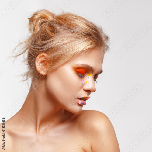 Portrait of a beautiful young woman with creative makeup. Light-gray background. Fashion and make-up concept.