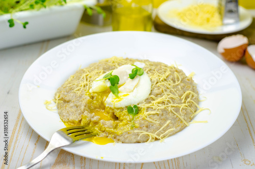 Oatmeal porridge with cheese and poached egg, healthy food for breakfast
