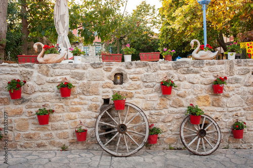 Red pots of flowers on a stone wall, Afitos, Halkidiki, Greece photo